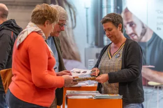 Adviseur toont folder aan 2 bezoekers